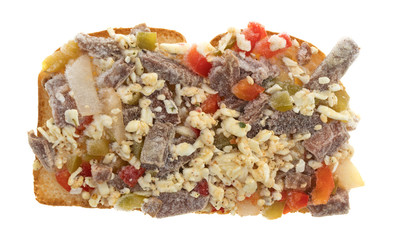 Steak cheese and vegetables frozen sandwich half isolated on a white background.