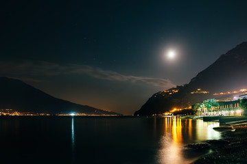 Naklejka na ściany i meble Full moon over night village Limone on Garda Lake