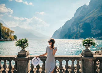 Young beautiful woman relaxing on picturesque Garda Lake - obrazy, fototapety, plakaty