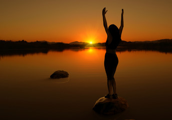 Silhouette of woman doing yoga at sunset