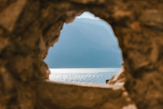 Fototapeta Stone window overlooking scenic landscape Garda lake