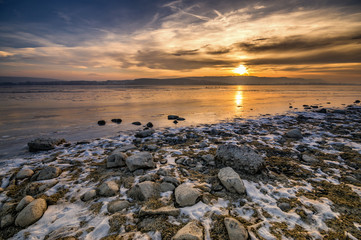 Fototapeta na wymiar Traumhafter Sonnenuntergang am Bodensee mit Steinen am Seeufer