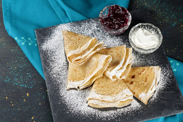 Russian pancake blini with fresh cream and berry jam on dark bac