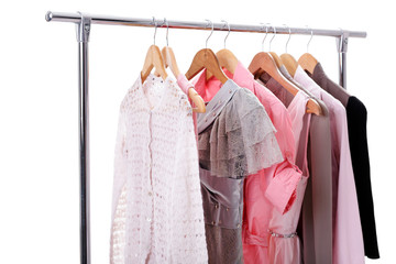 gray, pink womens clothes on hangers on rack on white background