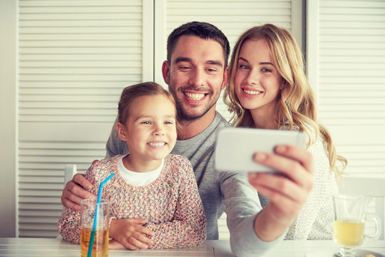 happy family taking selfie at restaurant