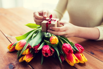 close up of woman with gift box and tulip flowers