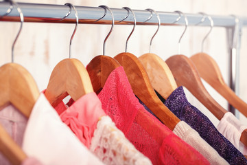 pink womens clothes on hangers on rack in fashion store. closet 