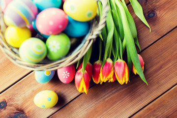 close up of easter eggs in basket and flowers