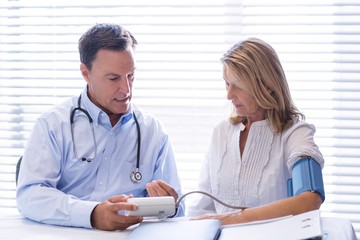 Doctor checking blood pressure of a patient in clinic