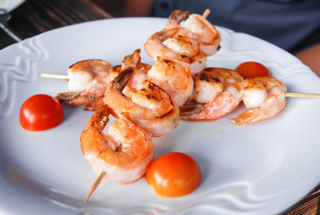 fresh grilled shrimps with tomatoes on white plate