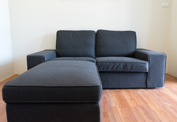 Dark blue sofa on wood plank floor with wall background space
