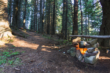 Cooking on fire in camp in mountain forest in summer