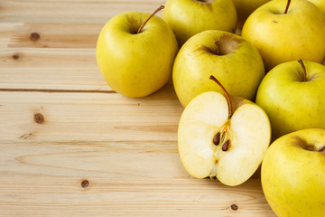 Naklejka na ściany i meble Golden delicious apples on a wooden background
