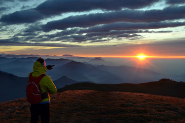 Alba in montagna con escursionista che indica