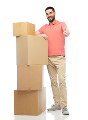 happy man with cardboard boxes showing thumbs up
