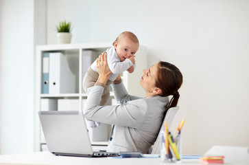 happy businesswoman with baby and laptop at office