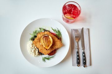 fish salad and glass of drink on restaurant table 