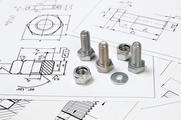 Printed engineering drawings, nuts and metal bolts. 