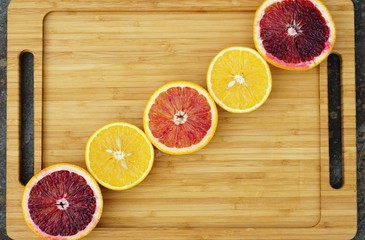 Diagonal row of orange citrus cut in half on a platter