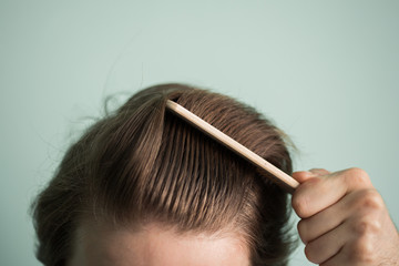 man with healthy hair holding comb - obrazy, fototapety, plakaty