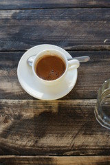 A cup of strong coffee on a table on a sunny day