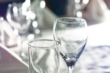 Clean glasses and cutlery on the table in a restaurant, cafe. Ba