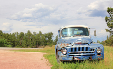 Old rusty vintage car by the road