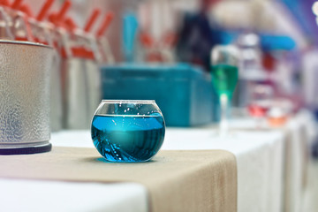 Festive Summer blue cocktail in a cafe restaurant. Background wi