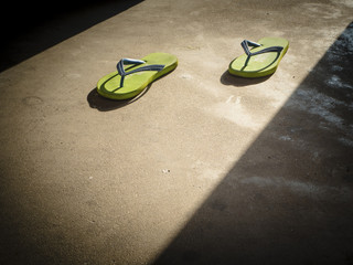 Green flipflop outside a house