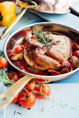 Chicken Tabaka in a pan with vegetables and tomatoes