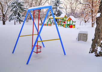 Children's playground covered with snow in winter