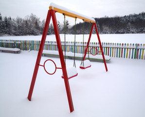 Children's playground covered with snow in winter