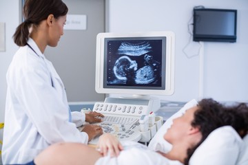 Obraz na płótnie Canvas Doctor doing ultrasound scan for pregnant woman