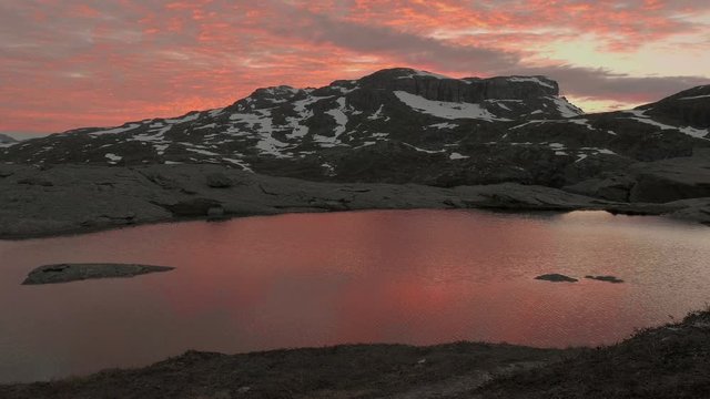 Sunset over the mountains lake, windy. Trolltunga, Norway. Smooth dolly shot