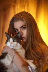 Portrait of a young girl in a warm color with a cat. 
