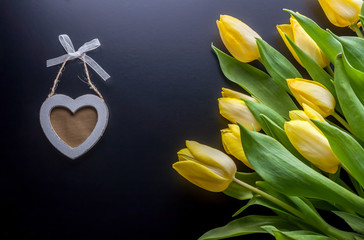 yellow tulips and wooden heart