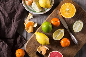 various types of citrus fruit on a dark wooden background