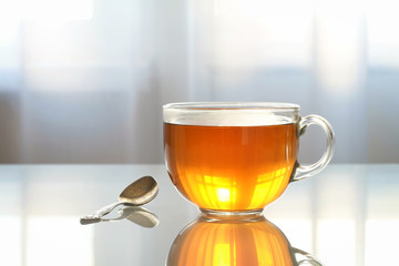Glass Cup with tea on a glass table