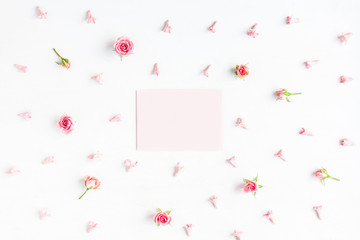 Paper blank and pink flowers on white background. Mockup with fl