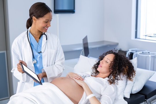 Doctor showing ultrasound scan on to pregnant woman