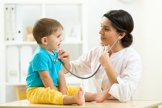 female doctor examining little child boy in hospital