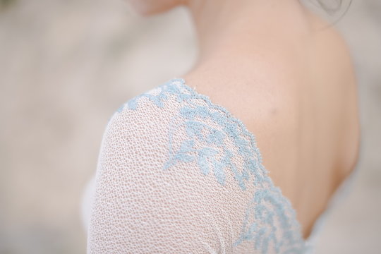 Nice blue lace wedding dress details. Back and shoulders of a happy bride on a wedding day. Love story. Beautiful bridal dress. Copy space.