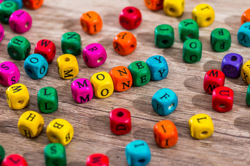 Word "money" of the colored wooden cubes on wooden desk.