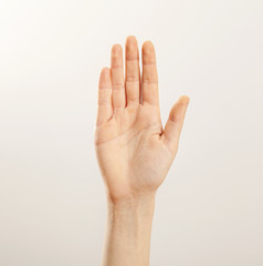 Woman hand raised on gray background