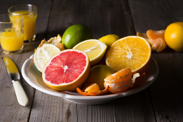 various types of citrus fruit on a dark wooden background