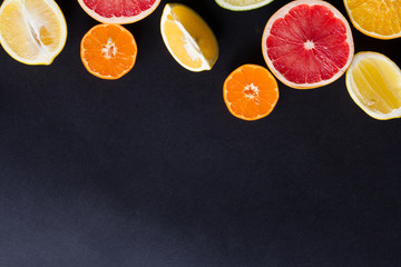 various types of citrus fruit on a dark background