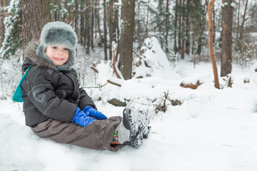 boy in the winter forest near trees