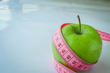 Green Apple with tape on a white background. Dieting
