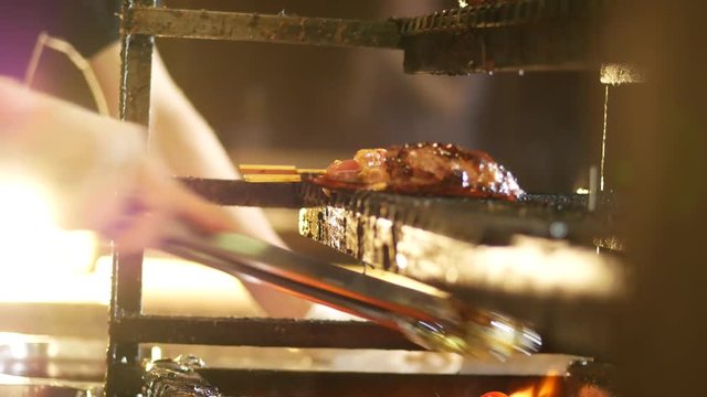 Cooking meat on grill at the kitchen with flame