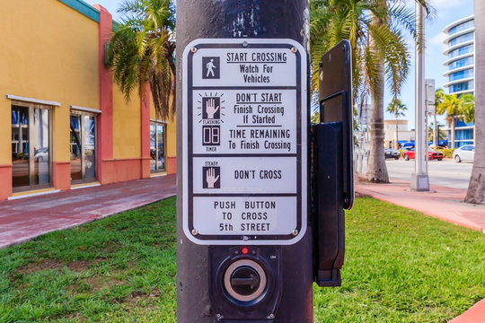 Young man hand pushing button for traffic light. Use traffic lights at the crossroads. Button of the mechanism lights traffic lights on the street. System control traffic light intersection close.